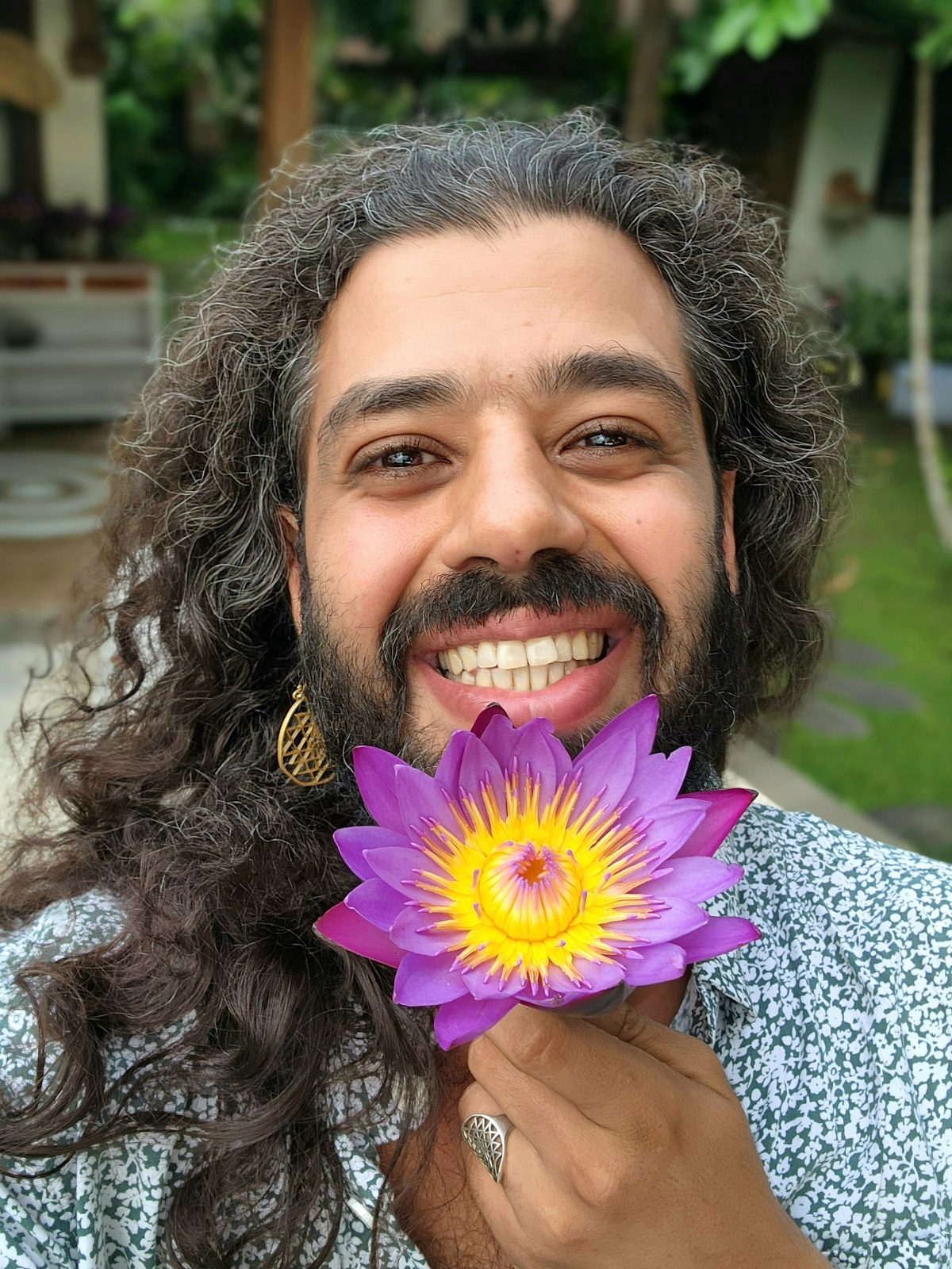 Ali Odeh holding a Blue Lotus bloom, examining it closely.