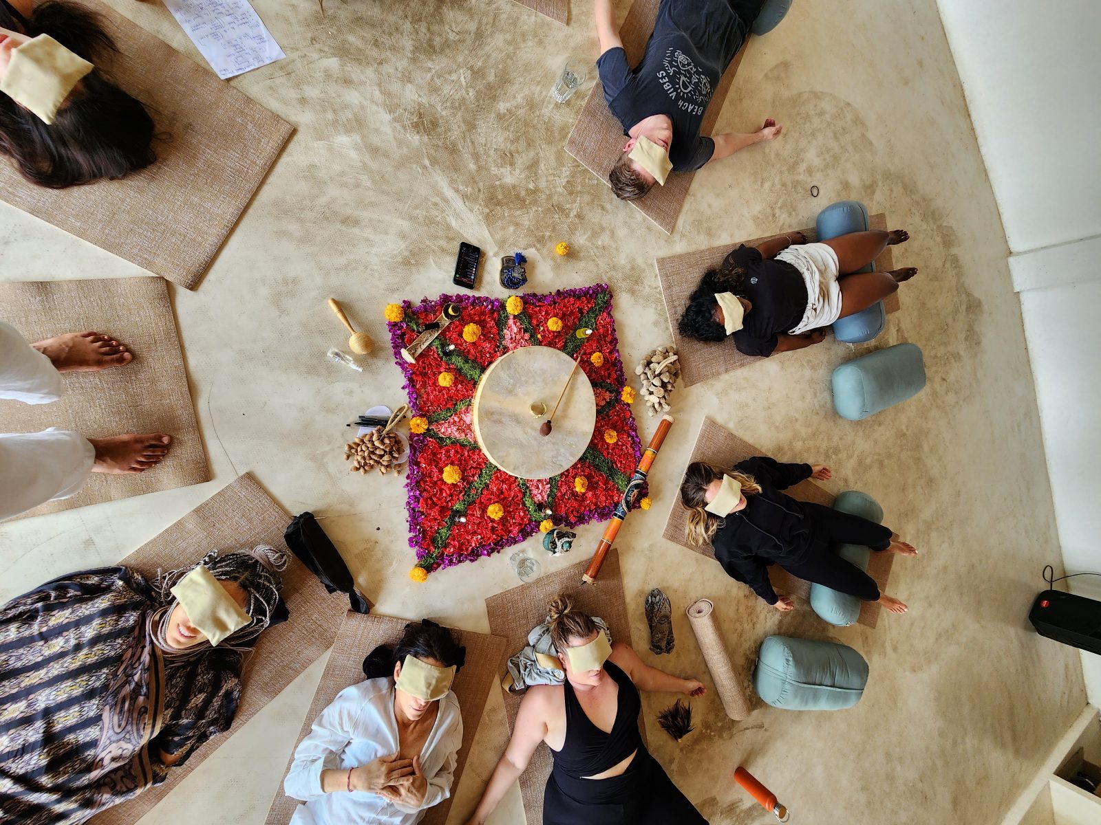 An overhead view of a group resting with eye pillows in an integration circle.