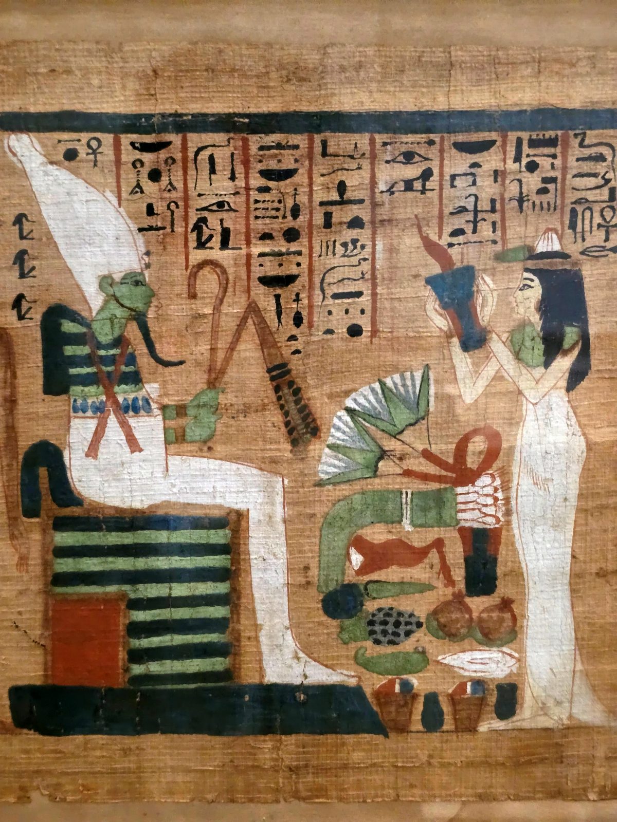 An Egyptian papyrus painting of a woman raising an offering vessel before the enthroned Osiris, with a laden offering table between them.