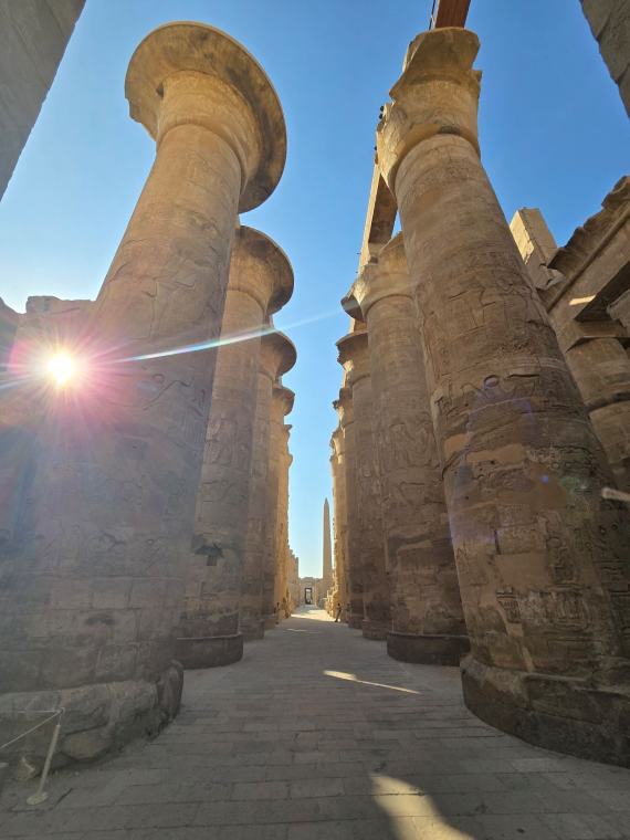 Sunlight between the great carved columns of the hypostyle hall at Karnak.